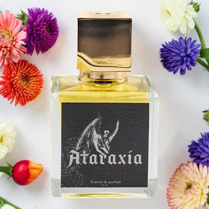 A square glass perfume bottle with a gold cap and a black label reading 'Ataraxia' and 'Extrait de parfum', surrounded by colorful flowers on a white background.