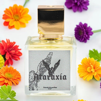 A square glass perfume bottle with a reflective gold cap, filled with pale yellow liquid. The front label reads 'Ataraxía' with a black winged figure illustration on a gray background. Ataraxia Vestibule | Fragrance Sample UK 1ml 2ml 5ml perfume samples 