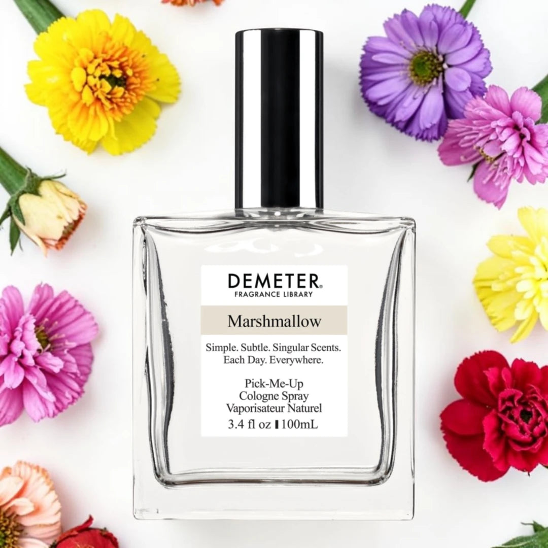 A bottle of Demeter Fragrance Library Marshmallow cologne spray, centered on a white background and surrounded by colorful flowers.
