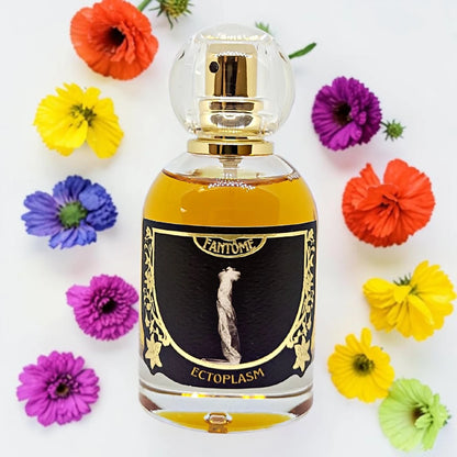 A bottle of Fantome L ectoplasm perfume with amber liquid, a black label with gold details, and a clear spherical cap, surrounded by colorful artificial flowers on a white background.
Fantôme Ectoplasm | Fragrance Samples UK 1ml 2ml and 5ml perfume samples available 
