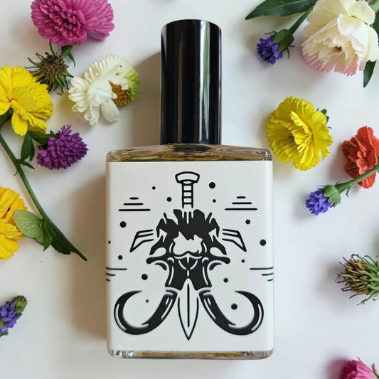 A square glass bottle with a black cap and a white label featuring a black graphic of a dagger, surrounded by colorful flowers on a white background.
House Of Mammoth You & I (Will Die) | Fragrance Samples UK 1ml 2ml 5ml samples available 