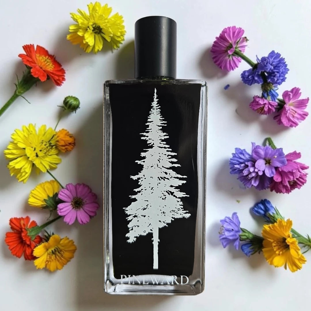A rectangular glass perfume bottle with a black label featuring a white tree silhouette, surrounded by colorful flowers on a white background. The brand name 'PINEWARD' is visible at the bottom of the bottle.
Pineward Murkwood | Fragrance Samples UK available in 1ml 2ml 5ml samples 