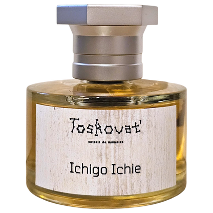 A bottle of Toskovat 'Ichigo Ichie' memory perfume with a silver cap and a light wood-grain label, containing a golden-yellow liquid, isolated on a white background.