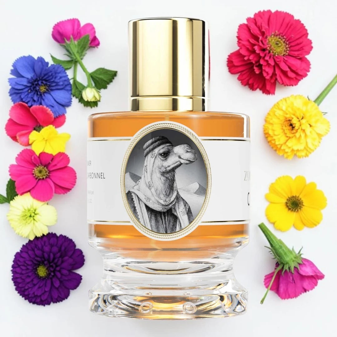 A clear glass perfume bottle with amber liquid and a shiny gold cap, centered on a white background and surrounded by colorful flowers including pink, yellow, purple, and blue blossoms.
Zoologist Camel | Fragrance Samples UK 1ml 2ml and 5ml perfume samples available