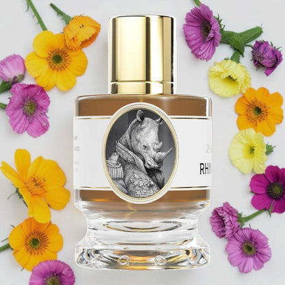 A clear glass perfume bottle with a shiny gold cap, filled with amber-brown liquid. The bottle has a white label featuring a circular black-and-white illustration of a rhinoceros wearing a coat, with partial text reading 'RHINO'. Zoologist Rhinoceros | Fragrance Samples UK