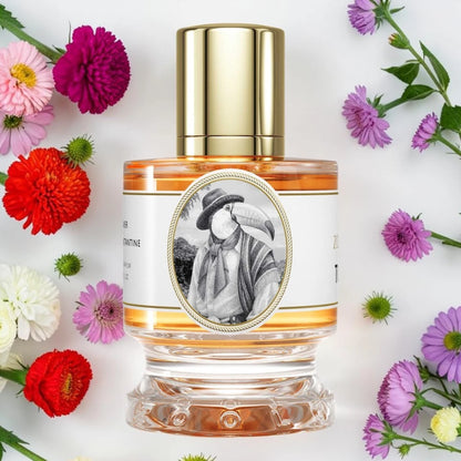 Zoologist Toucan | Fragrance Samples UK available in 1ml, 2ml & 5ml
A clear glass perfume bottle with a shiny gold cap and a white label featuring a black-and-white portrait, surrounded by colorful flowers on a white background.