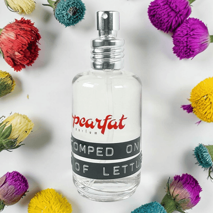 Pearfat Parfum Stomped on Bed of Lettuce Fragrance Samples bottle surrounded by colorful flowers.
