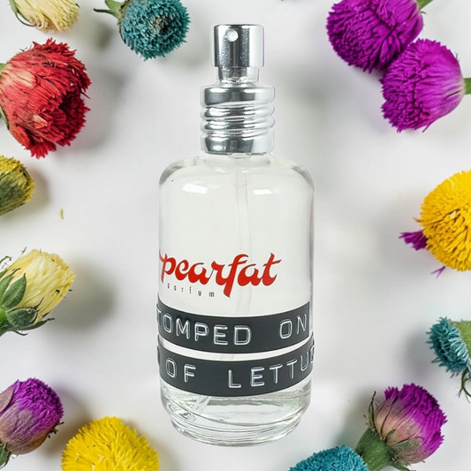 Pearfat Parfum Stomped on Bed of Lettuce Fragrance Samples bottle surrounded by colorful flowers.