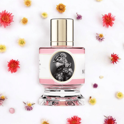 A bottle of Zoologist Nightingale perfume surrounded by colorful flowers, with a pink label and a image of a nightingale bird.